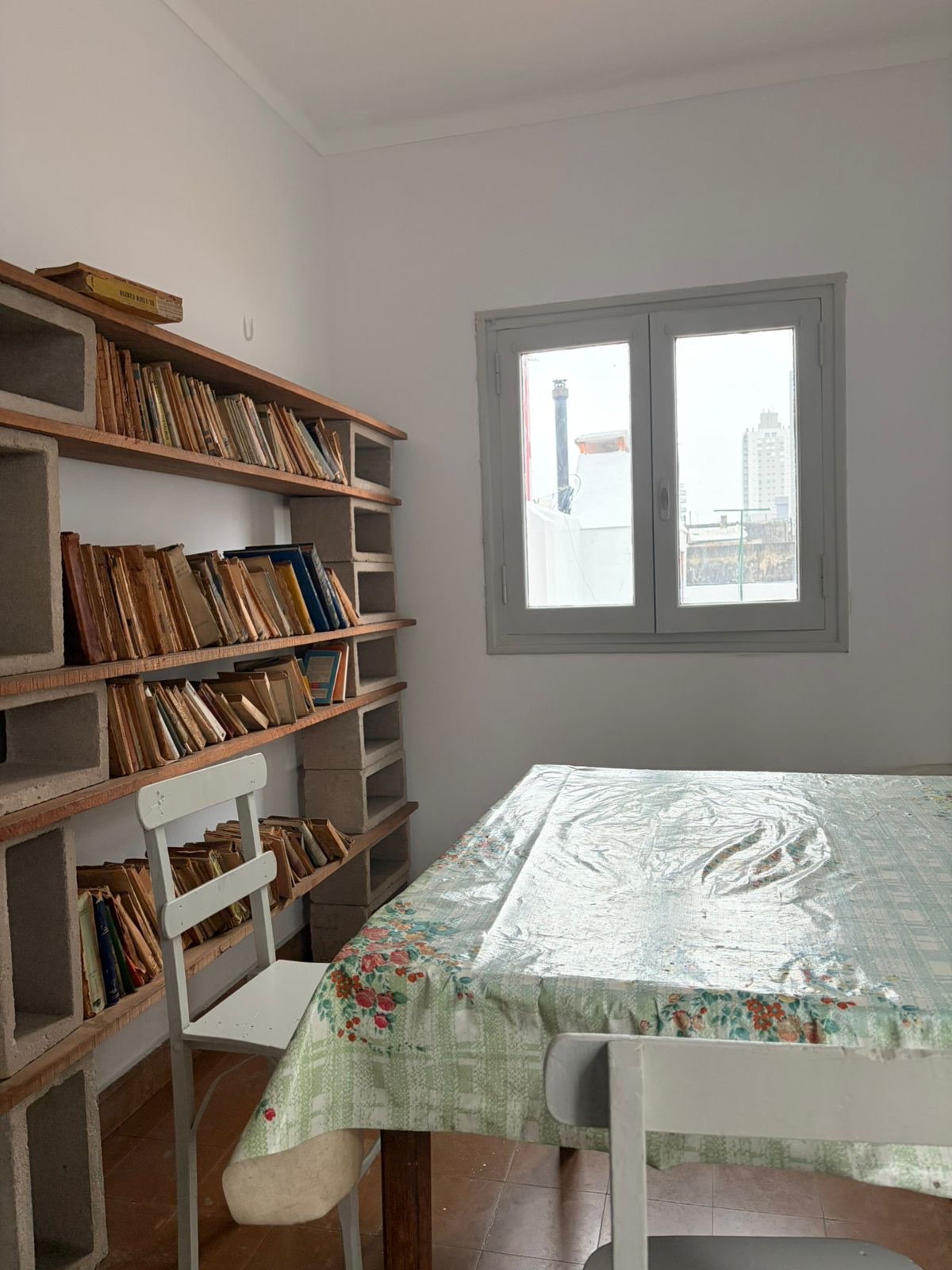 Biblioteca, mesa y ventana en una habitación de Casa Tomatis